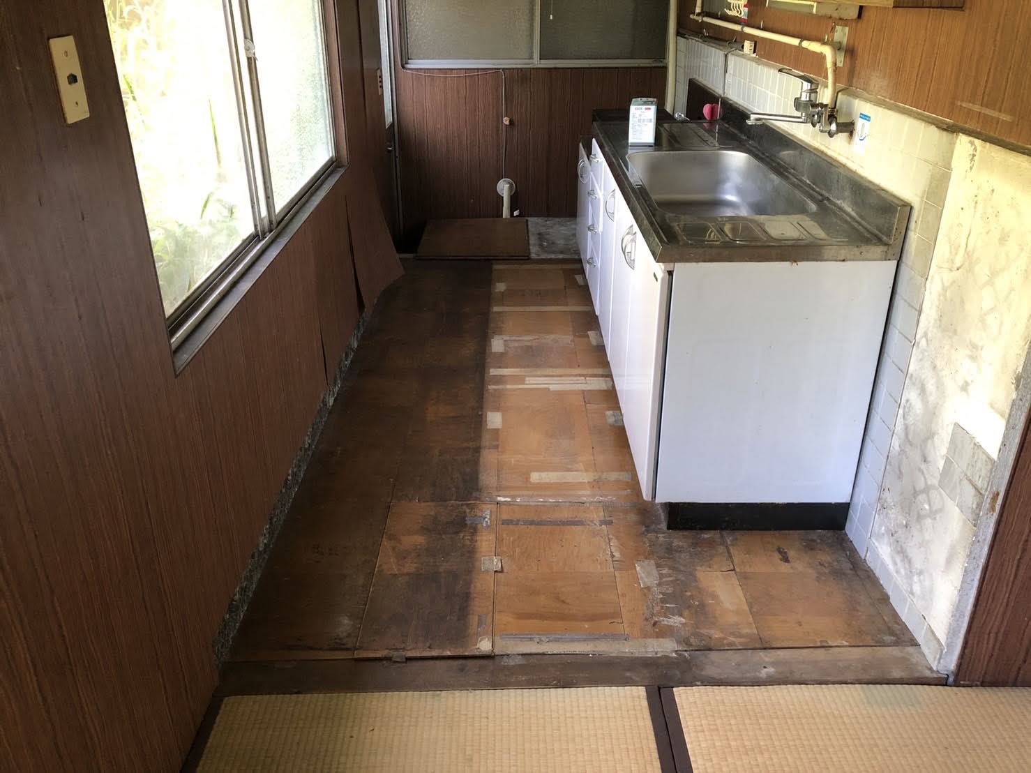 床板が浮いた古い民家の台所